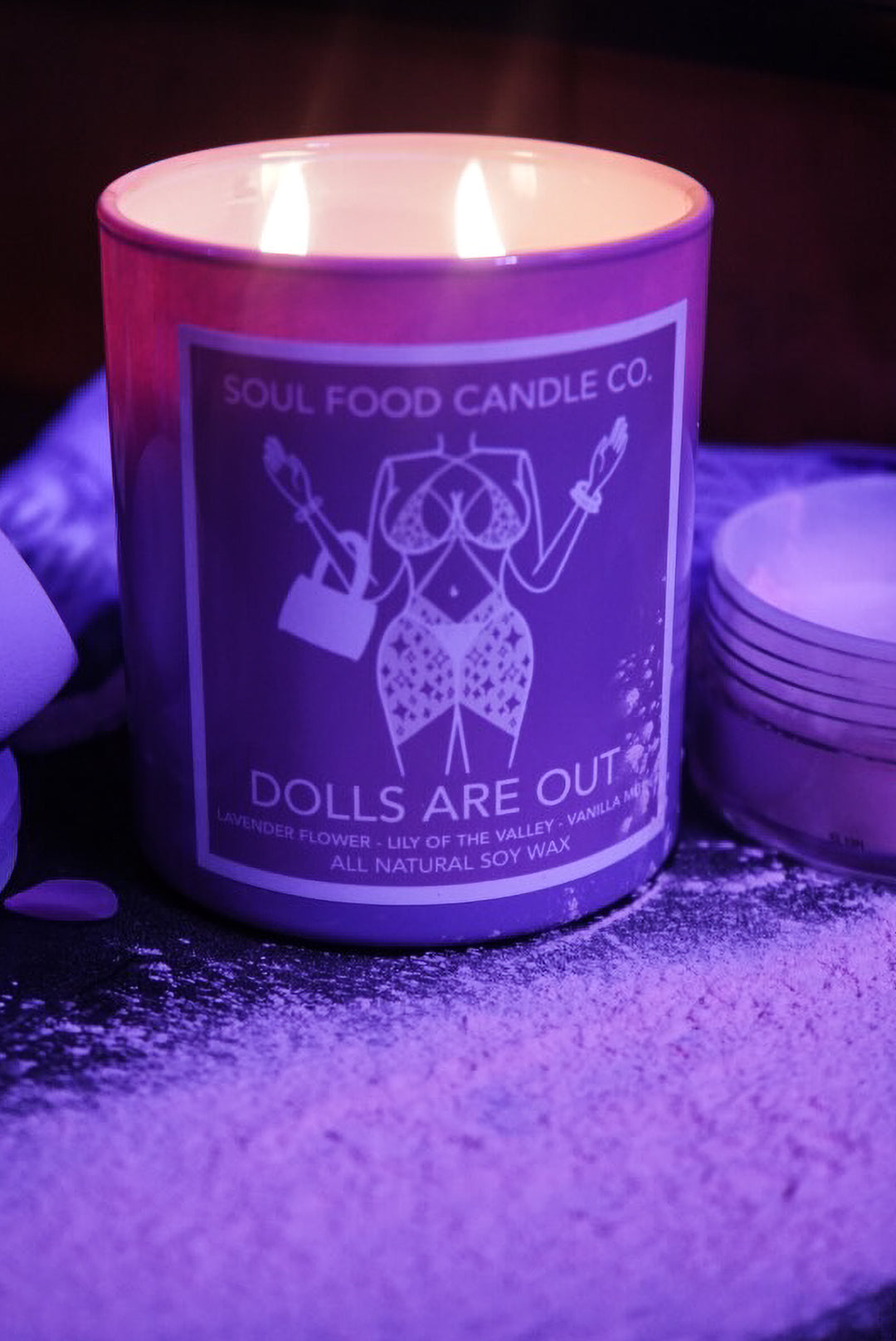 Soul Food Candle Co. candle with 'Dolls Are Out' design on a dark background